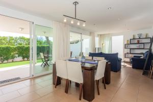 a dining room and living room with a table and chairs at Villa Jamaica in Fornells