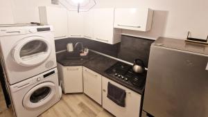 a small kitchen with a washing machine and a washer at Apartament Zakątek - Centrum in Szklarska Poręba