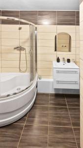 a bathroom with a tub and a sink at Apartament Zakątek - Centrum in Szklarska Poręba