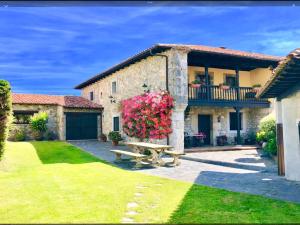 a stone house with a picnic table in the yard at Gran Pedroso de Llanes in Llanes