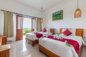 a hotel room with two beds and a balcony at Sarivanna Penida in Nusa Penida
