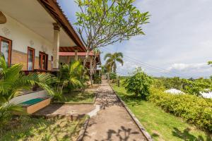a house with a walkway in front of a yard at Sarivanna Penida in Nusa Penida