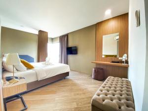 um quarto de hotel com uma cama e um espelho em Srilamduan Hotel em Si Sa Ket