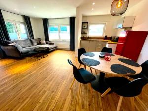cocina y sala de estar con mesa y sillas. en Südschleife Appartements - App. 2 - WLAN - Direkt am Ring, en Reimerath