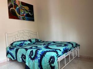 1 dormitorio con 1 cama con manta azul y blanca en Dahan Homestay en Kota Bharu