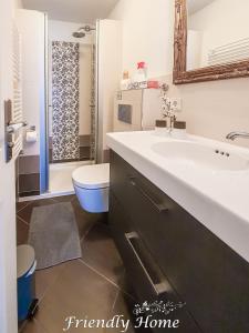 a bathroom with a white sink and a toilet at Friendly Home - "Gemütliches Backsteinhaus" Köln Bonn Phantasialand in Bornheim