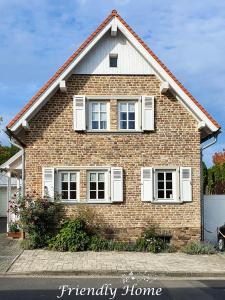 a brick house with white shutters on it at Friendly Home - Gemütliches Backsteinhaus in Bornheim