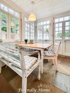 een eetkamer met een tafel, stoelen en ramen bij Friendly Home - "Gemütliches Backsteinhaus" Köln Bonn Phantasialand in Bornheim