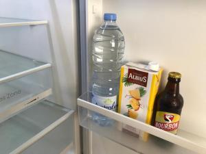 a bottle of water and a drink in an empty refrigerator at Central Montgaillard in Saint-Denis