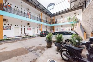 a large building with cars parked in a parking lot at RedDoorz near Kejaksan Station Cirebon in Cirebon