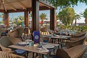 a group of tables and chairs in a restaurant at Kyma Suites Beach Hotel in Rethymno