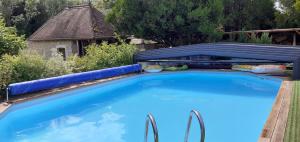 une grande piscine bleue dans une cour dans l'établissement Au P'tit Versailles, à Châtillon-sur-Seine