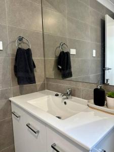 a bathroom with a white sink and a mirror at Hillston House in Kiama +17 photos