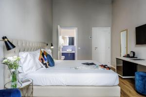 a bedroom with a white bed with a table and a desk at Dimora72 Luxury Rooms in Florence