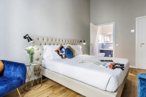 a bedroom with a white bed and a blue chair at Dimora72 Luxury Rooms in Florence
