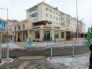 a woman walking in front of a building at 1 комн. Апартаменты на Абая 122 in Kokshetau