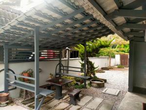 a pergola with a bench and a picnic table at AVENUE HOMESTAY 5 Room 4 Toilet 4 MINUTES TO TOWER in Teluk Intan