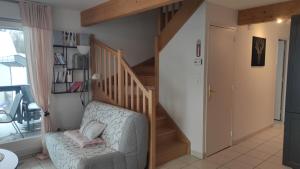 a living room with a staircase and a chair at Duplex Estelle - 2 couples ou famille in Gérardmer