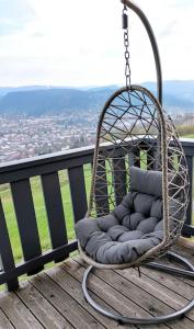 a hanging chair on a balcony with a view at Duplex Estelle - 2 couples ou famille in Gérardmer