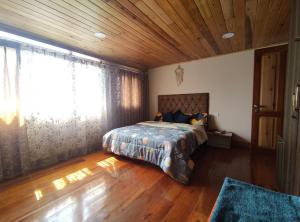 a bedroom with a bed and a wooden ceiling at Hello Home in Pelling