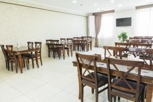 a dining room with wooden tables and chairs at A-Hotel Ex Magistral in Solnechnyy