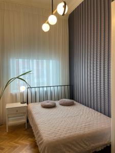 a bedroom with a bed with two pillows on it at Nightingale apartment in Liepāja