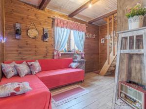 un soggiorno con divano rosso e pareti in legno di Stara hiža Vlašić a Kostanjevac