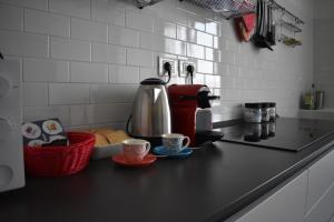 a kitchen counter with a coffee maker and two cups at La Mascarella in Alba