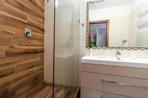 a bathroom with a sink and a mirror at Aqualiget-Apartmanház E-Car plug-in point Szeged in Szeged