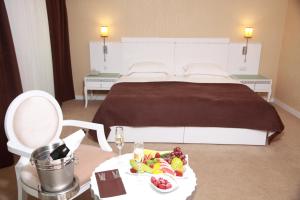 une chambre d'hôtel avec un lit et une table avec une assiette de nourriture dans l'établissement Amber Hotel, à Baku