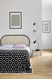 um quarto com uma cama preta e branca e um candeeiro em La Maison d'Ambronay em Ambronay