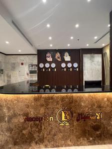 a restaurant with a counter with clocks on the wall at فندق بياك أوتيل الروضة in Makkah