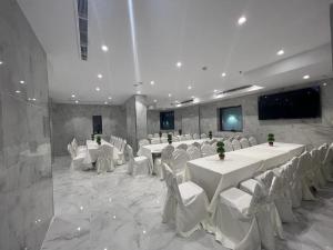 a banquet hall with white tables and white chairs at فندق بياك أوتيل الروضة in Mecca
