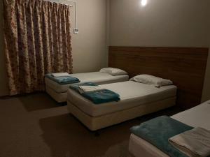a room with two beds and two o mattresses at Baron Water Front in Kuah