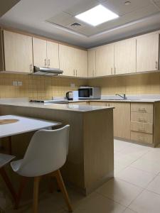 a kitchen with a counter and a white chair in it at Nice Al Marjan studio in Ras al Khaimah