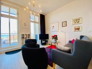 a living room with chairs and a tv and a couch at Villa Anna App. 7 Seeblick in Heringsdorf