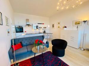 a living room with a blue couch and a table at Villa Anna App. 7 Seeblick in Heringsdorf +10 photos