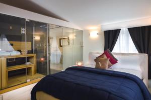 a bedroom with a blue bed and a glass wall at Villa Minieri Resort & SPA in Nola +68 photos