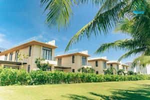 une rangée d'immeubles d'appartements avec un palmier dans l'établissement Lumina Villas Cam Ranh, Bai Dai beach luxury resort villas, à Cam Ranh