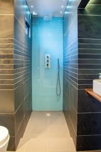 a bathroom with a shower with a toilet and a sink at Edge14- spacious, stylish and near the beach! in Newquay