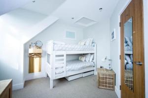 a room with a white bunk bed in a room at Edge14- spacious, stylish and near the beach! in Newquay