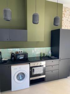 a kitchen with a washing machine and a washer at Petite Maison typique de ville marseille in Marseille