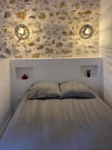 a bed in a bedroom with two mirrors on the wall at Petite Maison typique de ville marseille in Marseille