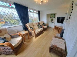a living room with a couch and chairs and a tv at Beach & Tonic beachside chalet in Humberston
