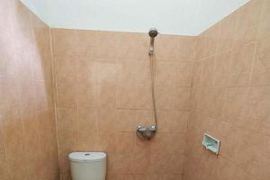 a shower in a bathroom with a toilet at Oka Homestay Mitra RedDoorz in Mataram