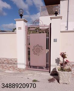 a white door with a gate with a flower on it at Villetta Giorgia in Avola
