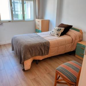 a bedroom with a bed and a wooden floor at Pensión Fornos in Caldas de Reis