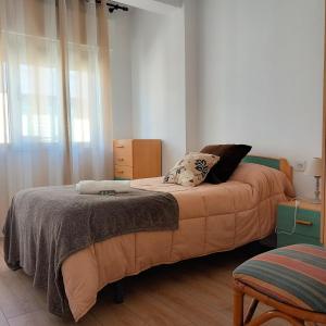 a bedroom with two beds and a chair in it at Pensión Fornos in Caldas de Reis +15 photos
