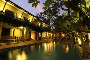 a swimming pool in front of a building at night at Rumah Batu Boutique Hotel in Solo
