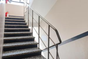 a staircase in a building with a metal railing at FabHotel Holiday Grand in Patna